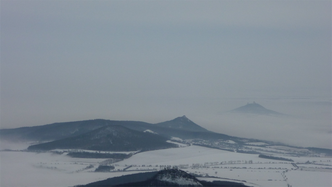 Sutomský vrch a Košťálov, vzadu Hazmburk.